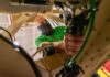 A worker at Tobyhanna Army Depot installs wiring on an Army satellite terminal