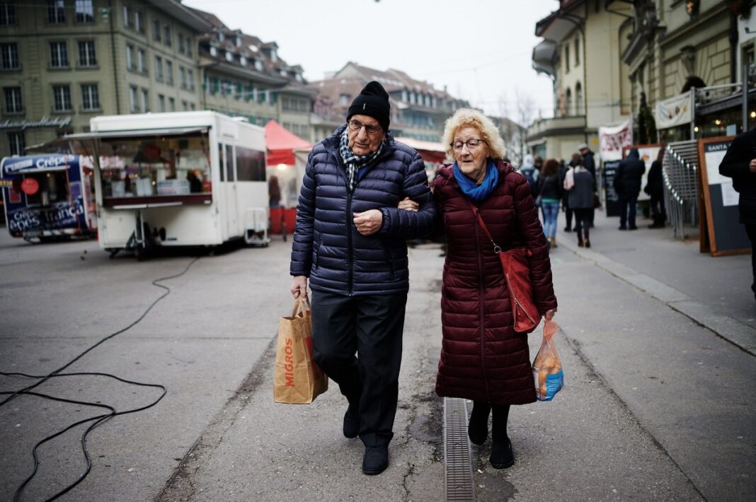 Alderley retired couple walking down a street in Bern, Switzerland