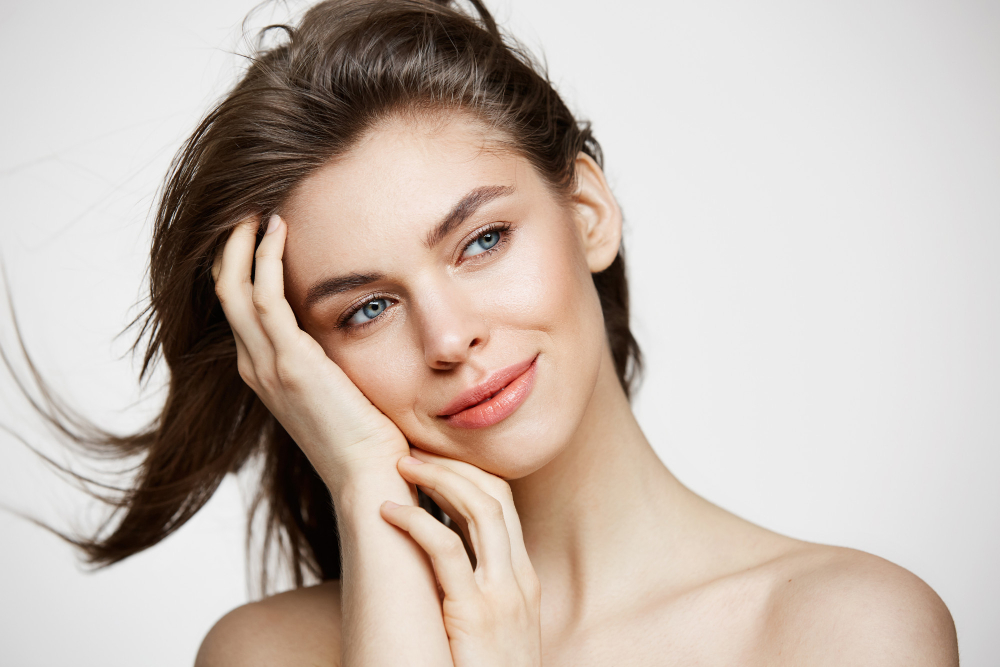 beautiful-naked-young-woman-with-perfect-clean-skin-smiling-touching-hair-white-wall-facial-treatment