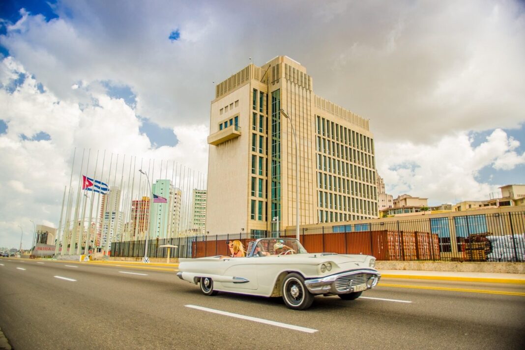 HAVANA, CUBA - AUGUST 30, 2015: The US embassy in the city of Havana, Cuba Old classic American cars used for taxi and tourist t